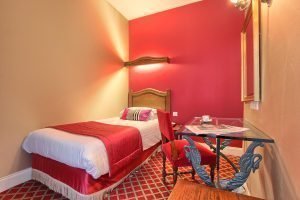 one sing ebed with pink fabric and a desk - hotel in Paris