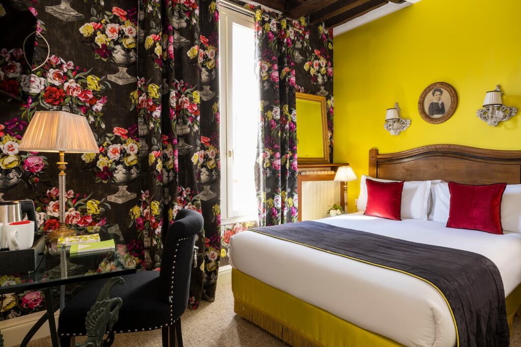 hotel in Paris - double room with flower fabrics and curtains, yellow fabrics, desk and black chair - romantic room Paris