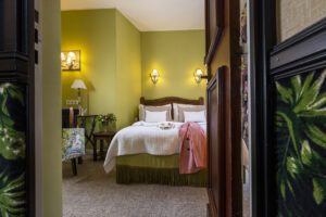 chambre pour deux avec tissu vert, lit blanc et lumières allumées à l'hôtel des marronniers - hotel proche de l'université paris Descartes