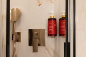 salle de bain chambre double hotel de charme paris avec produits clarins, gros plan sur pomme de douche et robinet