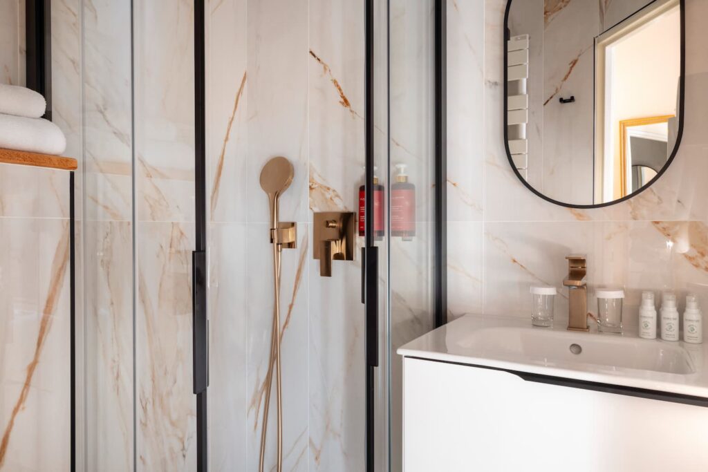 salle de bain chambre hotel romantique avec marbre, douche, produits clarins, tiroirs