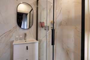 salle de bain chambre double hotel de charme avec douche, marbre, miroir rond et tiroirs