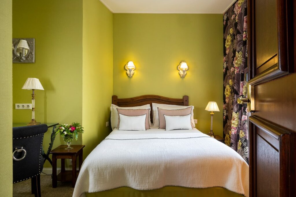 chambre double hotel de charme - vue sur le lit avec coussins et tissus vert