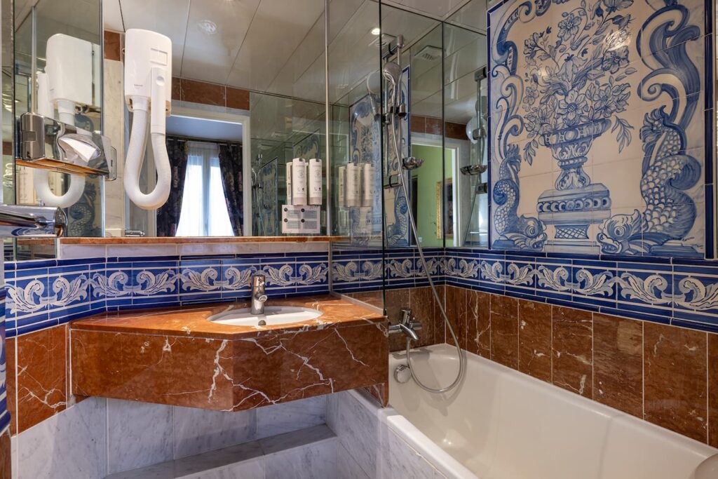 marble bathroom with bathtub, hair dryer and sink - double room boutique hotel