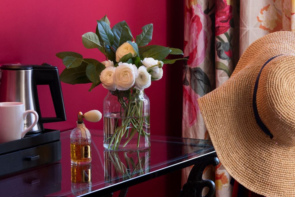 desk with courtesy tray, flowers and a hat - king size room Paris - hotel des marronniers