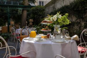 photo chambre hôtel de charme table de jardin dressée dans le jardin pour le petit-déjeuner avec nappe blanche