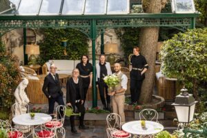 team of the hotel des marronniers smiling in the garden - boutique hotel Paris