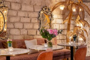 photo chambre hôtel de charme - fleurs sur une table en marbre avec mobilier rose et voutes de pierre