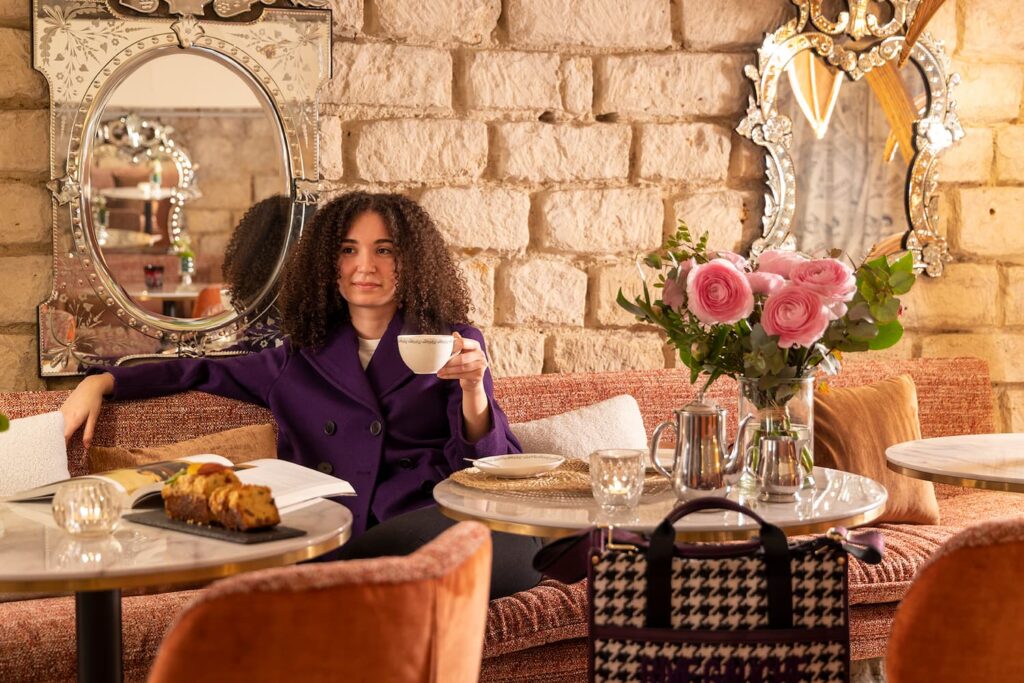 afternoon tea in Paris - woman having a cup of tea in the vaulted lounge of the hotel des marronniers
