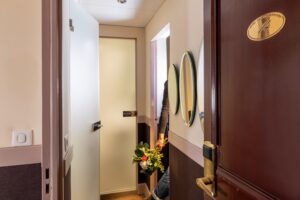 hotel chambre familiale couloir vers les deux chambres avec un homme qui tient des fleurs