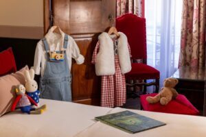 hotel chambre familiale avec tenues enfants pendues au placard en bois