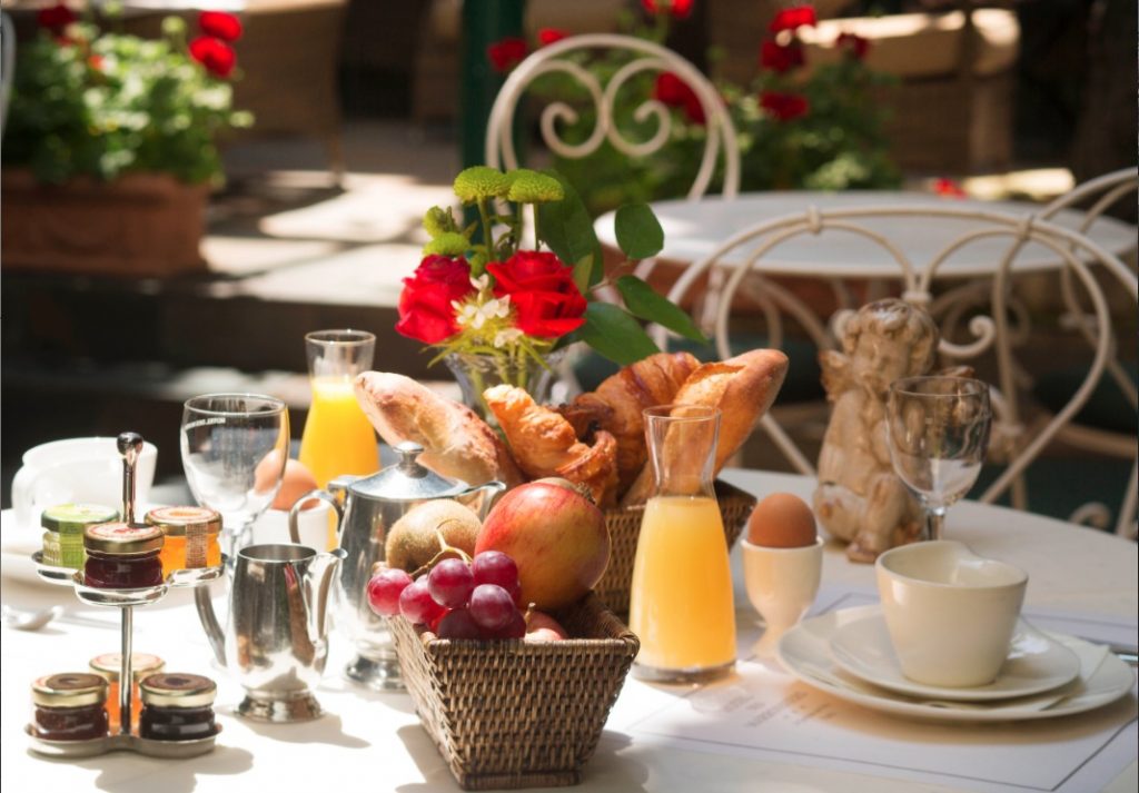 Table dressée pour un petit-déjeuner dans le jardin de l'hôtel des marronniers à paris 6 - tarif flexible BB