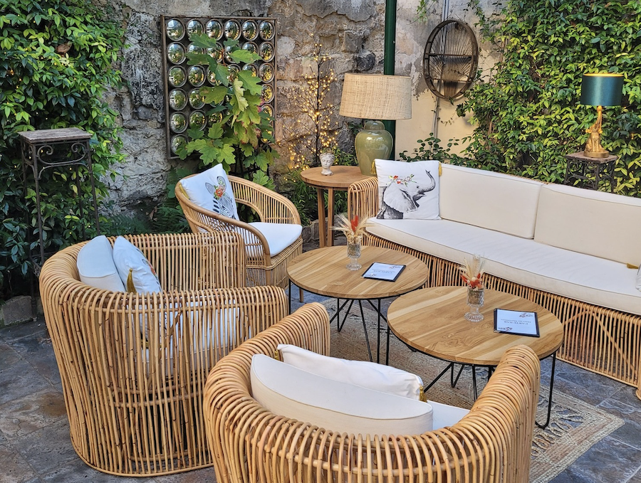 salon de thé en extérieur dans le jardin de l'hôtel des marronniers - canapé et fauteuils en osier 