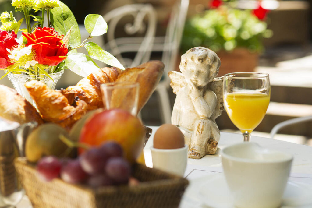 petit-déjeuner hôtel Paris : petit-déjeuner en terrasse à l'hôtel des marronniers avec fruits frais, oeufs durs, jus d'orange, café.
